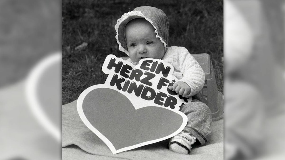 Ein Baby mit einem XL-Aufkleber von "Ein Herz für Kinder" © Rolf Kremming