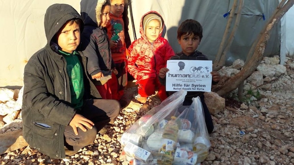 Kinder in einem Flüchtlingscamp im Umland von Aleppo mit den gelieferten Lebensmitteln. 