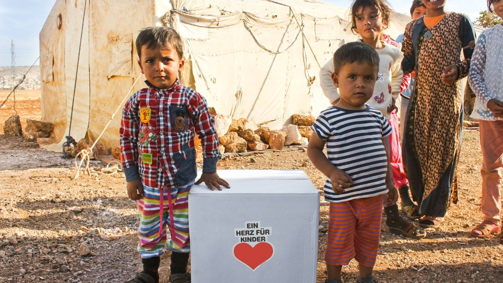 Flüchtlingskinder mit einem Überlebenspaket