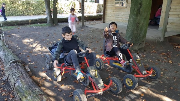 MiKiBu-Kinder fahren Kettcar auf dem Bauernhof
